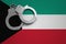 Kuwait flag and police handcuffs. The concept of crime and offenses in the country