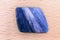 Kyanite jewel stone texture on varnished wood background.