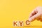 kyc. hand folds wooden blocks in the inscription kyc on an orange background.