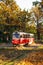 Kyiv, Pushcha-voditsa, october 10, 2021. Red retro tram goes along the route through the autumn forest. Atumn landscape with tram