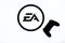 Kyiv, Ukraine - December 03, 2020: Backlit single shot image of Electronic Arts logo on tv screen with SONY Dualshock lying on the