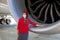 Kyiv, Ukraine - July 1, 2020: Turkish Airlines flight attendant standing near airplane engine. Boeing 787 Dreamliner engine.