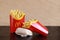 Kyiv, Ukraine - March 22, 2023: Two large portions of french fries and a cheeseburger, side view