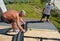 KYIV, UKRAINE - October, 09, 2019: Roofer laying asphalt shingles on new roof. Roofer contractors installing asphalt shingles on