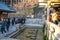 Kyoto, Japan - 2 Mar 2018: People waiting in the row, scooping water from 3 holy water lines with long handle cup and pray of his/