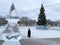 Kyshtym, Russia, January, 15, 2020.  Elderly woman walks past the main Christmas tree in the city of Kyshtym in front of the house