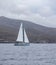 Kythnos island, Greece. Sailboat cruising in blue sea background. Vertical