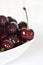 l juicy fresh summer cherries in a white bowl on a vintege background