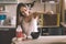 L woman breakfast pours cereal from box into bowl