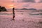 La Digue Seychelles, sunset on the white tropical beach with palm tree, young woman on vacation at the Seychelles