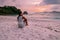 La Digue Seychelles, sunset on the white tropical beach with palm tree, young woman on vacation at the Seychelles