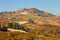 La Morra town on hill surrounded by fields, vineyards in autumn in Italy