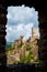 La Tour Regine and Cabaret sight through a stone window at Lastours