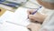 Lab researcher writing research report. Female researcher in lab. Closeup of lab scientist hand writing notes. Woman