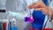 Lab scientist pouring liquid in lab flask. Scientist doing laboratory experiment