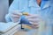 Lab technician hands in medical gloves holding a container with litmus paper for measuring the PH, alkalinity, acidity
