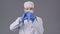 Lab technician in medical uniform and mask picks up syringe, pours some liquid