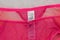 Label M&S on lacy pink panties on white fur. Close up. Fashionable concept of lingerie