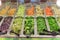 Labeled slice red and green cabbage, broccoli, snap pea, green bell pepper, sprout arugula at salad bar