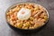 Lablabi Tunisian Spicy Chickpea Stew with green olive, canned tuna and poached egg closeup in the bowl. Horizontal
