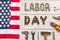 Labor day. American flag and Inscription labor day and various tools on a light wooden background