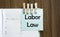 Labor Law notes paper and a clothes pegs on wooden background