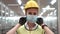 Labor woman worker is wearing protection mask face and safety helmet and wearing suit green reflective safety dress in high tech