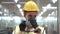 Labor woman worker is wearing protection mask face and safety helmet and wearing suit green reflective safety dress in high tech