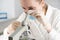 The laboratory assistant examines the samples under a microscope