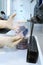 The laboratory assistant holds an open container with biological cultures in his hands. Hands in protective gloves. Clinical