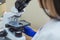 Laboratory assistant is looking through a microscope. Close-up doctor laboratory assistant looking through a microscope,