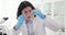 The laboratory assistant looks at the seeds in a flask