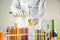 Laboratory assistant pouring liquid from test tube into flask over table