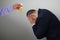 Laboratory assistantâ€™s hand holds a test tube with yellow liquid, businessman sits with his head in his hands, symbol of