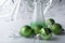Laboratory beaker with green liquid and smoke near cristmas balls on white background