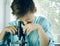 Laboratory. funny boy intently looking through a microscope. close-up