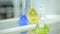 Laboratory glassware with color liquid and with reflection. test tubes and flasks with green and blue liquid in a