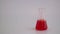 Laboratory glassware with liquid on white background. glass chemical flask with reagent
