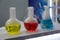 Laboratory glassware with solutions of different colors on table