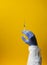 Laboratory hand in medical gloves vaccine treatment research on yellow background