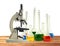 Laboratory metal microscope and test tubes with liquid on wooden