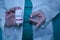 Laboratory personnel in white coats holding a bottle of antiviral pills against the Covid 19 virus in one hand and in the other a