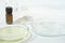 laboratory petri dishes with growth medium or culture medium and powder on a table. essential oil in amber glass bottle