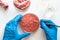 Laboratory studies of artificial meat. Minced meat in Petri dish under the supervision of a scientist in gloves. View from above