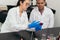 Laboratory technicians examining growths on cell culture plates. They are seen taking safety precautions by wearing goggles,