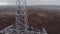 Laborer on lattice power transmission tower top aerial view