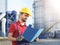 Laborer outside a factory working dressed with safety overalls e