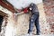 Laborer pierce a big round hole in a brick wall