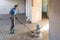 Laborer polishing sand and cement screed floor.