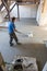 Laborer polishing sand and cement screed floor.